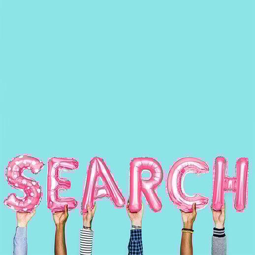 hands holding balloons that spell out search